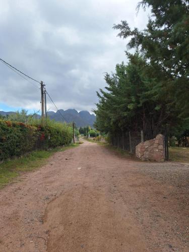 a dirt road with trees on the side of it at Pinares de Cacheuta in Las Heras