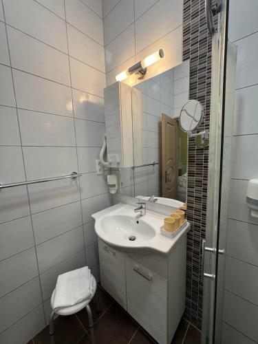 a white bathroom with a sink and a mirror at Szem-s Vendégház in Balatonszemes
