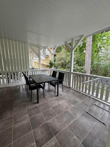 a patio with a table and chairs on a porch at Szem-s Vendégház in Balatonszemes