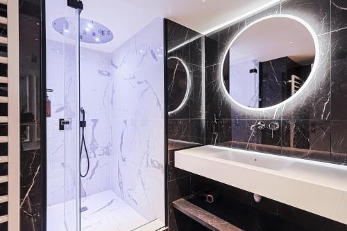 une salle de bain avec un lavabo et un miroir dans l'établissement Divine Couture - Suite Rive Gauche, à Carrières-sur-Seine
