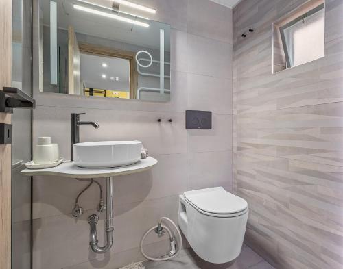 a bathroom with a toilet and a sink at Kyma Holiday Loft in Artemida