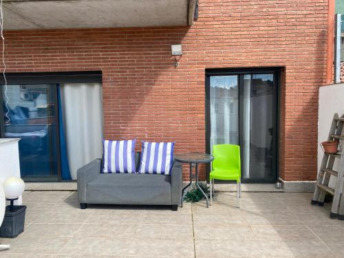 a patio with a chair and a table and a brick wall at Tranquilo y con terraza in Terrassa
