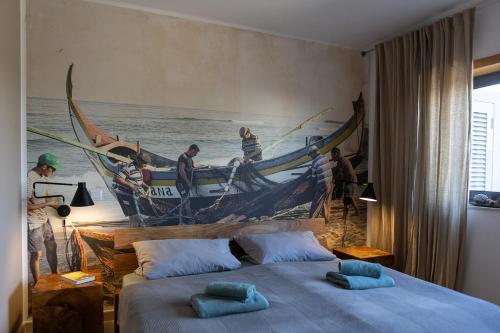 a bedroom with a painting of boats on the wall at maresoul - Ferienapartment mar in Raposeira