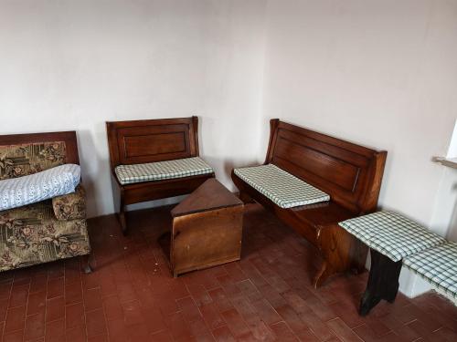 a room with three wooden chairs and a bed at Casale Valdilana in Mosso Santa Maria