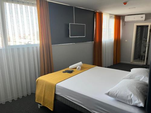 a hotel room with a bed with a yellow blanket at Polo Suit Otel in Avcılar