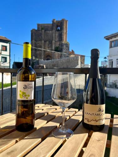 two bottles of wine and a wine glass on a table at El Patio de Vespasiano- San Juan- vistas al ayuntamiento junto al puerto in Castro-Urdiales
