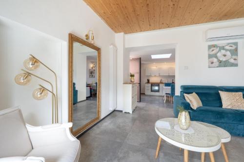 a living room with a blue couch and a mirror at Lora villa, with lake view in Ossuccio