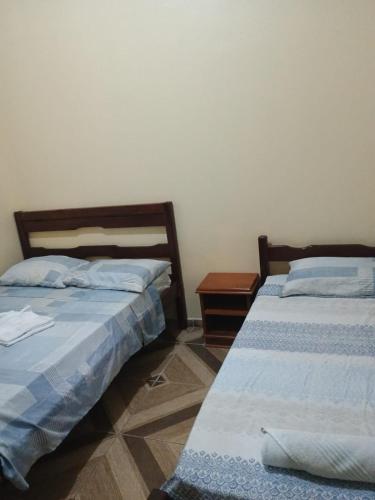 two beds sitting next to each other in a bedroom at Pousada Amigu's in Pontal do Paraná