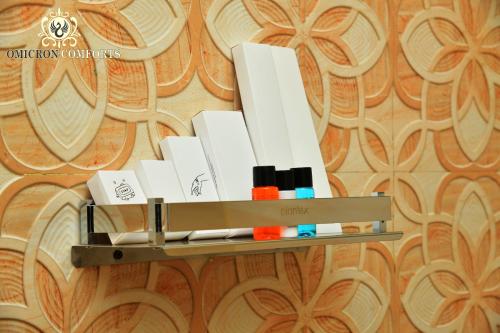 a shelf with makeup brushes and cosmetics on a wall at Deluxe AC Room by Omicron Comforts-Manyata Tech Park in Bengaluru