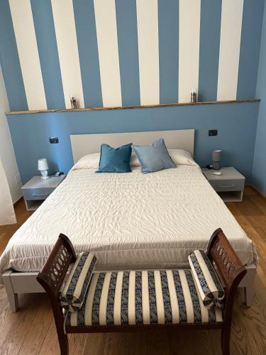 a bed with two pillows and a bench in a room at Rooms primo piano in Modena