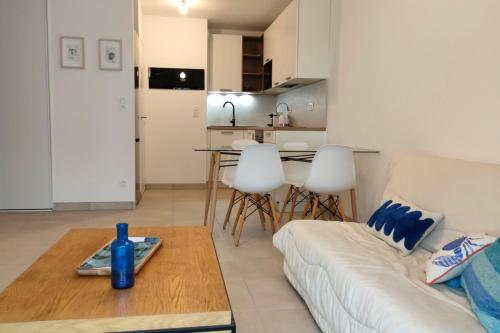 un salon avec un canapé blanc et une table dans l'établissement 1-bedroom apartment in residence, à Dinard