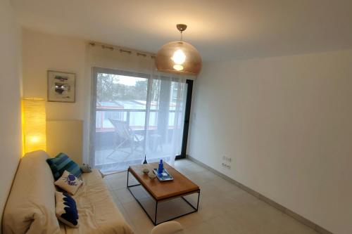 un salon avec un canapé et une table dans l'établissement 1-bedroom apartment in residence, à Dinard
