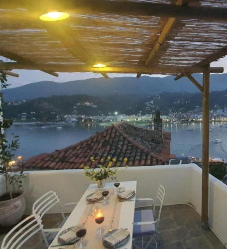 a table on a balcony with a view of the water at Mona in Poros