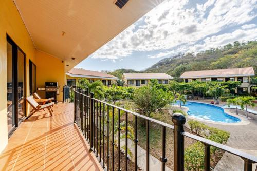 a balcony with a view of a pool and mountains at Casa Fe- Newly Renovated 2 bedroom condo in Ocotal
