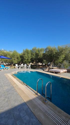 a swimming pool with two chairs and a table at Chambre Suite Paco avec accès piscine in Midoun