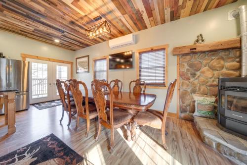 a dining room with a table and a fireplace at Home with River View and Game Room in Tidioute! in Tidioute