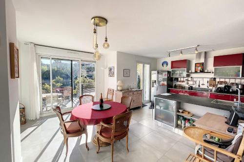 une cuisine et une salle à manger avec une table et des chaises rouges dans l'établissement Peaceful villa with pool and garden - 5 minutes from Cannes beaches, à Cannes