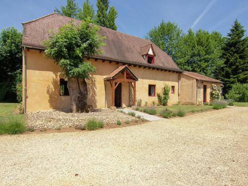 ベナック・エ・カズナックにあるCharming Cottage with Pool in V zac South of Franceの目の前に木が立つ大きな黄色の建物