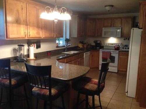 a kitchen with wooden cabinets and a table with chairs at Red Cliffs Rental in Kanab