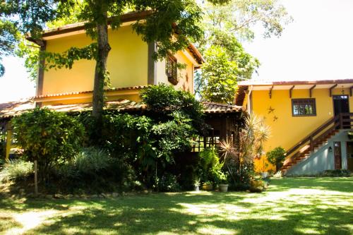 a yellow house with a yard in front of it at Pousada da Mata in Iriri