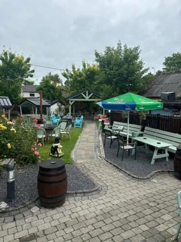 a patio with picnic tables and an umbrella and a barrel at Retreat by the Feale in Listowel