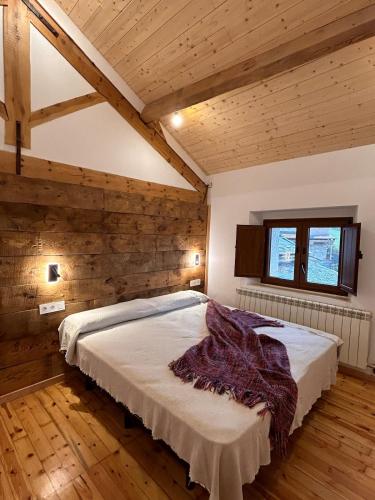 a bedroom with a bed in a room with wooden ceilings at Cal Not La Masia, Cerdanya in Escardacs