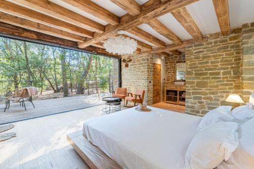 une chambre avec un lit et un mur en pierre dans l'établissement Bastide provencale et ses dépendances à 5 kms de la plage, à Ceyreste