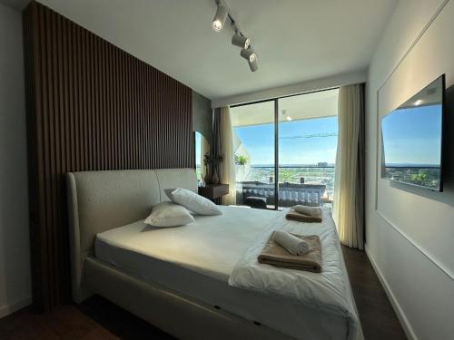 a bedroom with a large bed with two towels on it at Grand Sapphire Luxury Residence By MyGuest Cyprus in Iskele