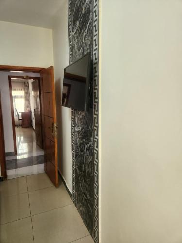 a living room with a tv on a wall at Hôtel SAN PEDRO in Yaoundé