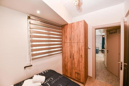 ラリサにあるComfy Dots 1のソファと木製キャビネット付きの客室です。