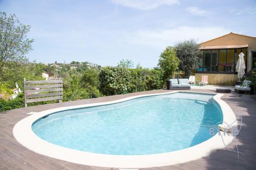 une piscine dans une cour avec une maison dans l'établissement Pretty villa in greenery ecrin, à Le Rouret