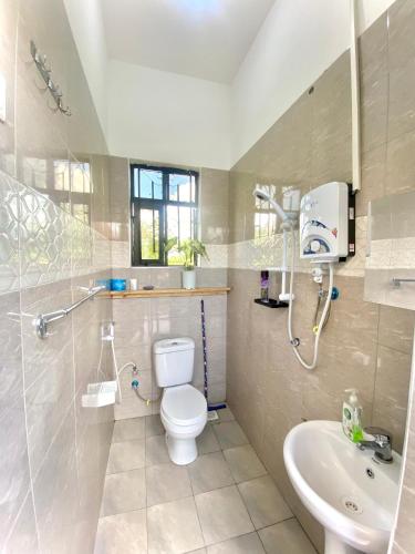 a bathroom with a toilet and a sink at Shambani House in Arusha
