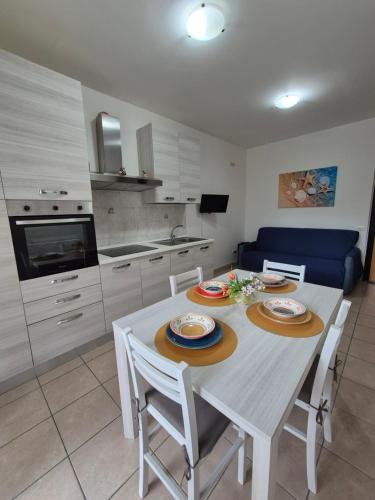 a kitchen and dining room with a white table and chairs at Appartamento a 100m dal mare in Grottammare