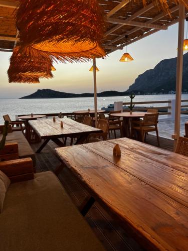 a restaurant with tables and chairs and a view of the water at SPONGIA HOTEL SUITES & Spa in Myrties