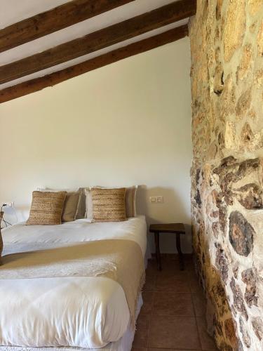 two beds in a room with a stone wall at Agroturismo Finca Son Pieras in Llucmajor