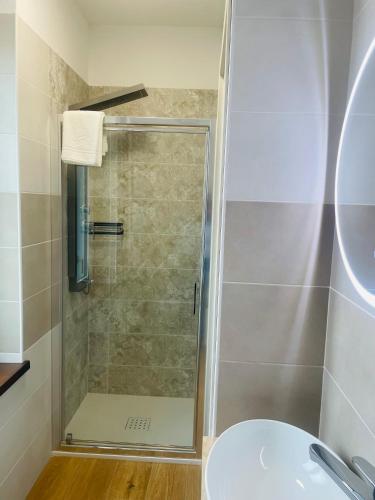 a shower with a glass door in a bathroom at Airport Flower Rooms in Ronchi dei Legionari