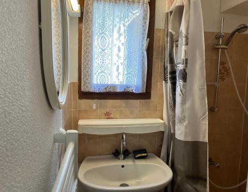 une salle de bain avec un lavabo et une fenêtre dans l'établissement Duplex house Les Villas de La Palmyre, aux Mathes