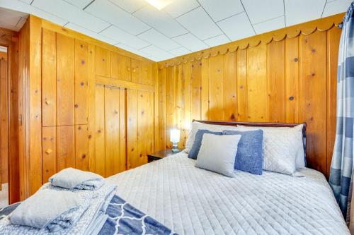 a bedroom with wooden walls and a bed with blue pillows at Mountain Retreat at Base of Pikes Peak! in Cascade-Chipita Park