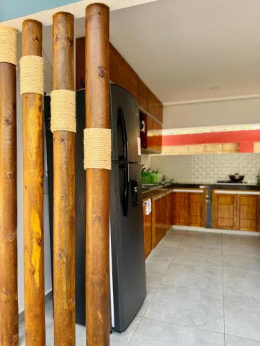 a kitchen with bamboo poles and a refrigerator at Cabaña La Roca in San Antero