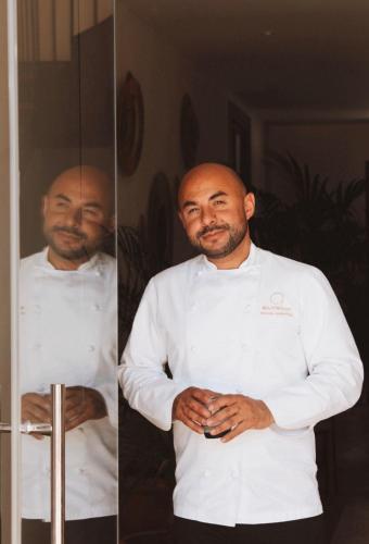 a chef standing in front of a mirror at Elysium Luxury Stays in Melegis