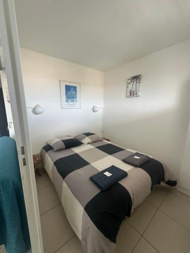 una camera con un letto bianco e nero di Bleu Marine Apts a Lacanau-Océan