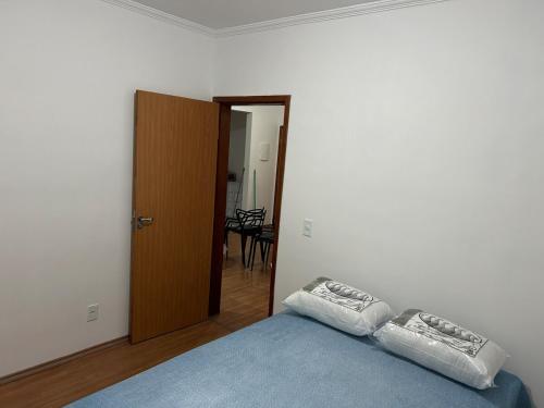 a bedroom with a bed with two pillows on it at Confortável Apartamento em Condomínio in Pouso Alegre