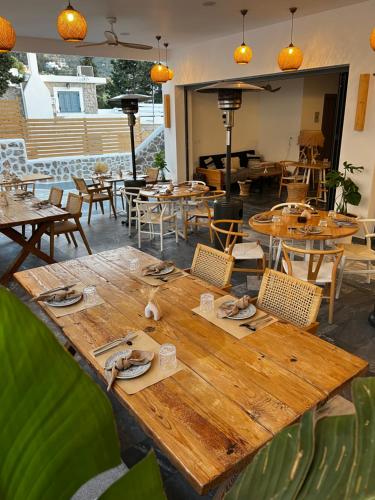 a wooden table in a restaurant with tables and chairs at SPONGIA HOTEL SUITES & Spa in Myrties