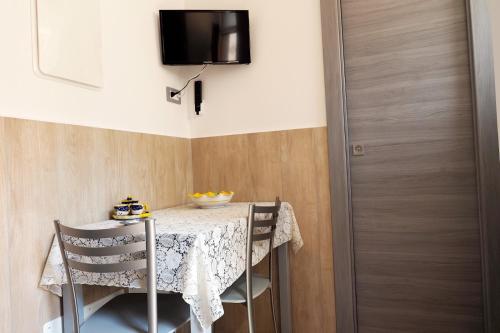 a table with two chairs and a television on a wall at Ammiria in Cetara