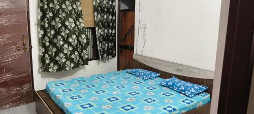 JāmbにあるPihu guest houseの青い枕2つが備わるベッド1台