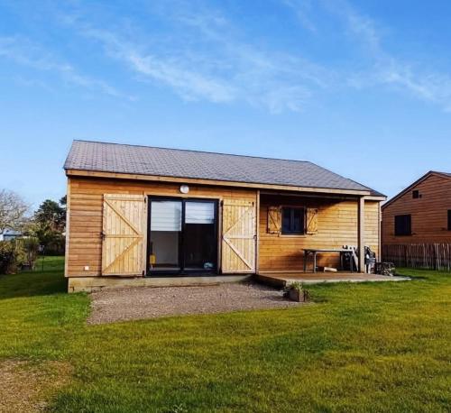 une petite cabane en bois avec une table dans une cour dans l'établissement La Maison de la Mer, à Plobannalec-Lesconil