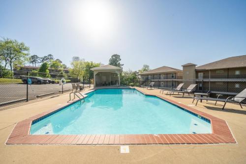 a large swimming pool at a hotel with benches and tables at The Oasis on Lake Hamilton with Pool in Hot Springs