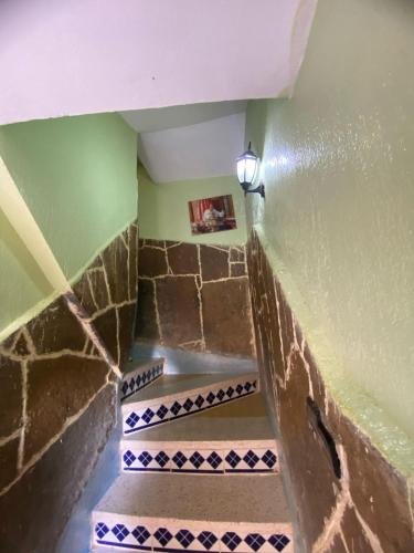 a staircase with blue and white tiles in a room at Maison d'hôtes Moussem des fiançailles in Imilchil
