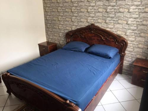 a bedroom with a wooden bed with blue pillows at Appartement situé en plein cœur d'Agadir in Agadir
