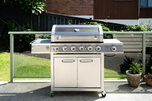 a grill sitting on a cart in a yard at Spacious Coastal Retreat, Ideal for Families in Mangawhai